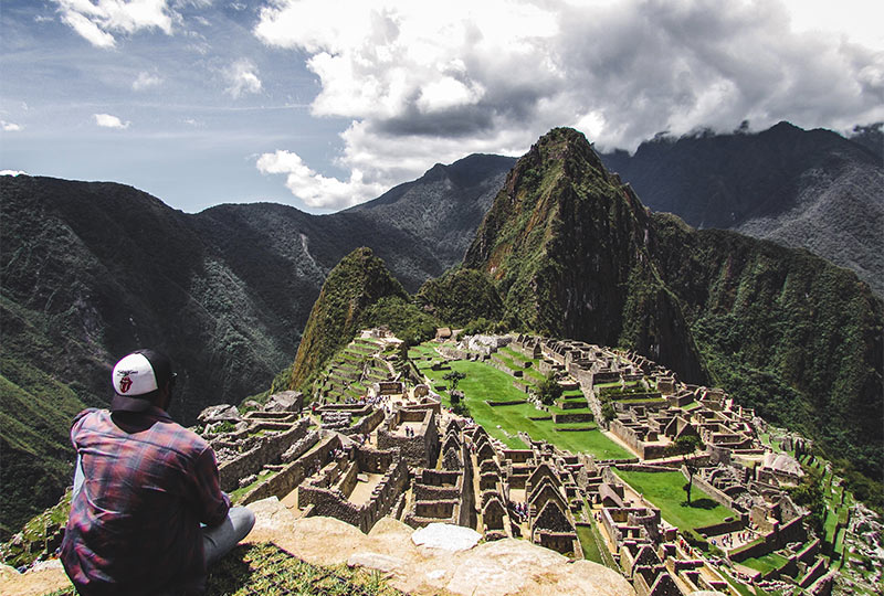 Traveler enjoying the view of famous Machu Picchu; during the best time to hike Machu Picchu