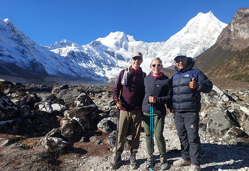Himalayan Glacier guests posing with their guide in front of Mount Manaslu